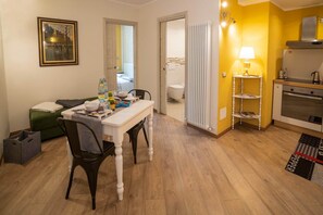 A compact living space with a dining area, kitchenette, and a view into the bathroom. - Colleoni 20. Standard Apartment. Apartment located in the Upper Town, at Via Colleoni 20. (Bergamo)