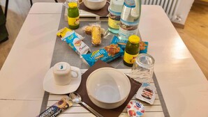 Ein Tisch mit Frühstücksangeboten, darunter eine Tasse, Teller, eine Schüssel und verschiedene verpackte Lebensmittel.