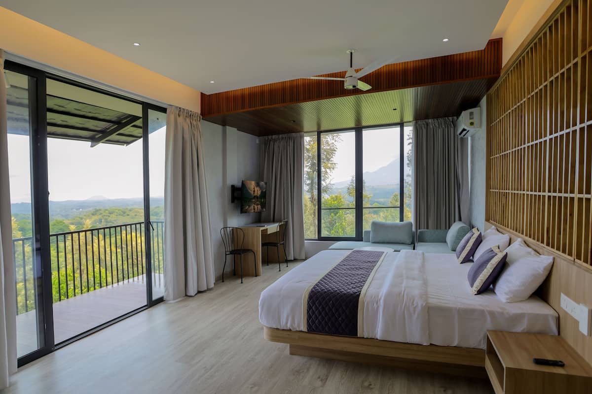 Un dormitorio con una cama grande, un escritorio y vistas al exterior.