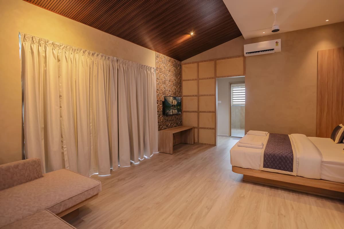 Un dormitorio moderno con techo de madera, una cama, un banco y una pared de piedra.