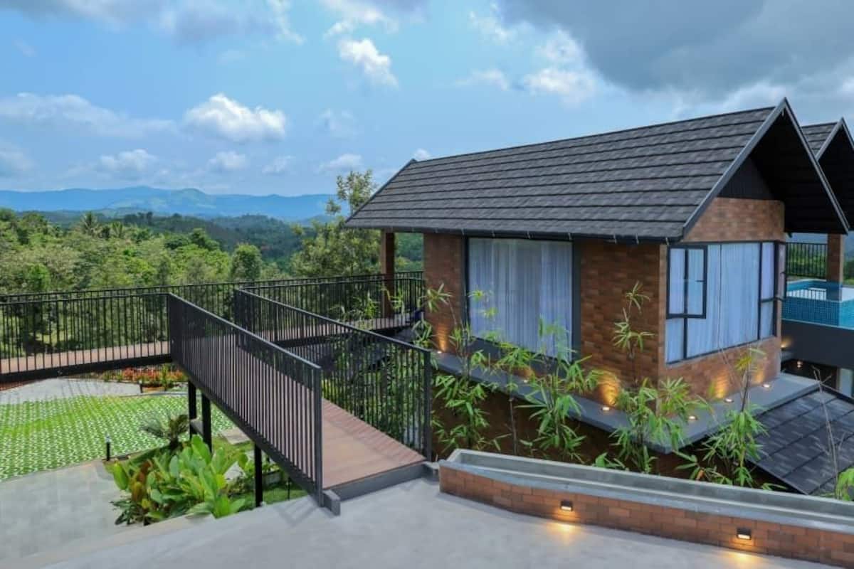 Una casa moderna con balcón, escaleras y piscina.