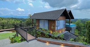 Een modern huis met balkon, trap en zwembad.