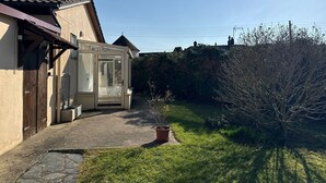 Een huis met een oranjerie, een stenen pad en een tuin.
