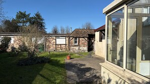 Een gebouw met een groot glazen raam, een stenen muur en een gazon.