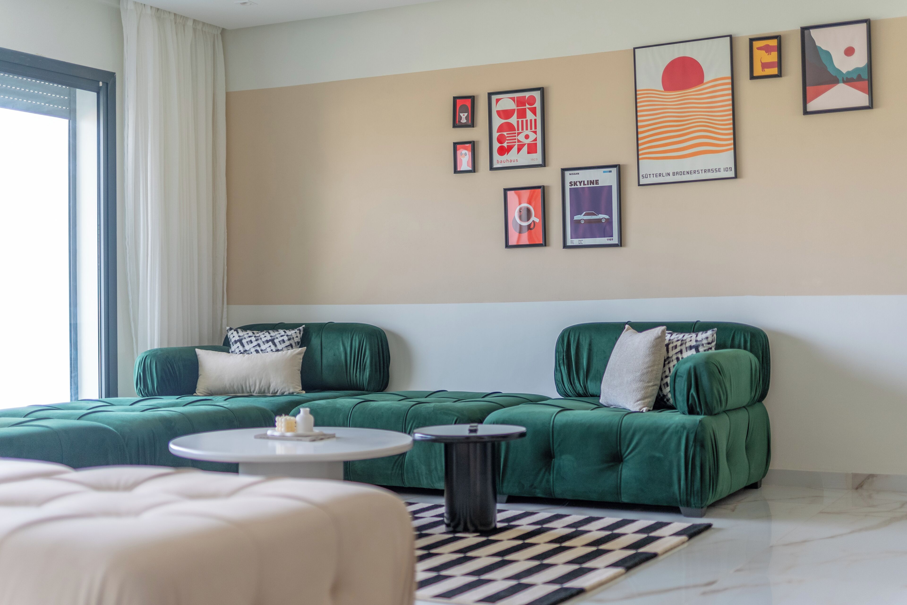 Una sala de estar moderna con un sofá verde, una mesa de centro redonda y una alfombra a cuadros.