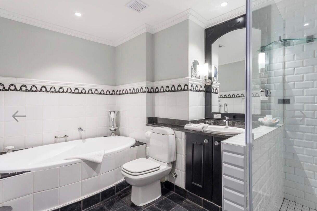 A modern bathroom with a bathtub, toilet, and sink.