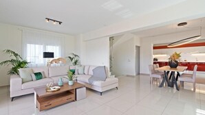 Ein modernes Wohnzimmer mit einer Couch, einem Couchtisch und einem Essbereich.