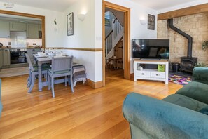 A living room with a TV, sofa, and a fireplace. - Mill Village 43, Dragonfly - Spa & Swimming Pool Access, Watersports & Pet Friendly, Sleeps 6 (Somerford Keynes)