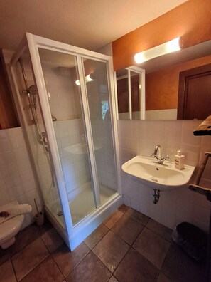 A bathroom with a glass-enclosed shower, a sink, and a mirror. - Charming Historic House in Provincia di Cuneo, Italia (Mombarcaro)