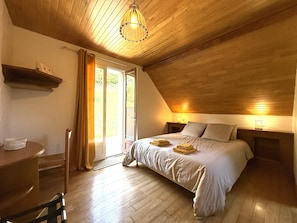 A bedroom with a wooden ceiling, a bed with pillows and a blanket, a bedside table, and a window with curtains. - Charming gîte in Borce, view of the Pyrenees, calm and unspoilt nature. (BORCE)