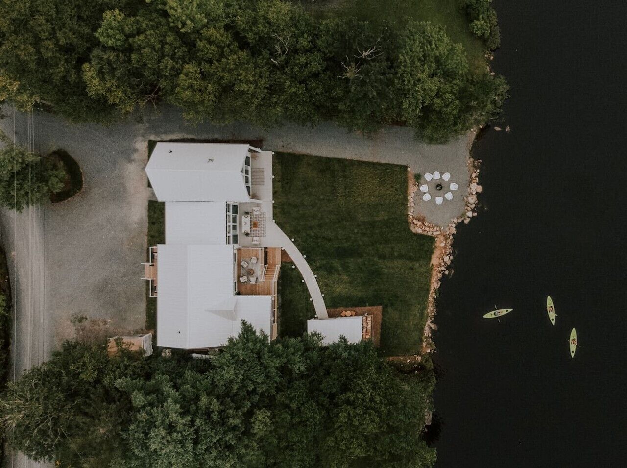 Luchtbeeld van een huis met een groot terras, een zwembad en een ligplaats voor boten.