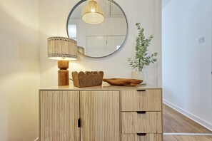 A wooden cabinet with a mirror, a woven basket, a wooden bowl, and a potted plant. - 2 Bed Bungalow| Parking| Garden Leigh-on-Sea (Southend-on-Sea)