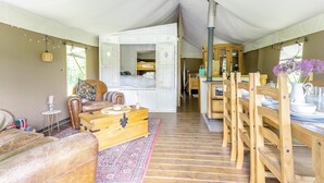 A tented accommodation with a central seating area, a kitchenette, and a dining setup. - 3 Bed in Arley (oc-s42696) (Pound Green)