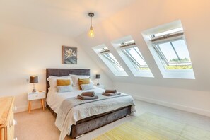A bedroom with a bed, bedside tables, a lamp, a painting, and skylights. - 3 Bed in Bude (oc-c42469) (Bude)