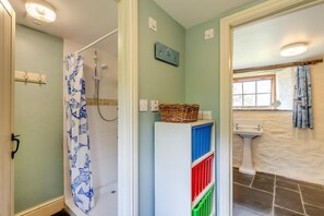 Un baño con ducha, lavabo y ventana.