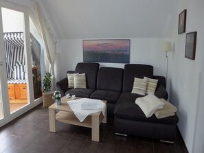 Ett vardagsrum med en soffa, ett soffbord och en tavla på väggen.