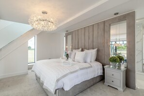 A bedroom with a large bed, a nightstand, a mirror, and a chandelier. - 1 Bed in Claxby St. Andrew (oc-r42838) (Claxby St. Andrew)