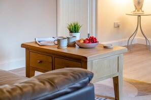 A wooden side table with a bowl of fruit, a potted plant, and a cup. - 3 Bed in Lanreath (oc-j42768) (Lanreath)