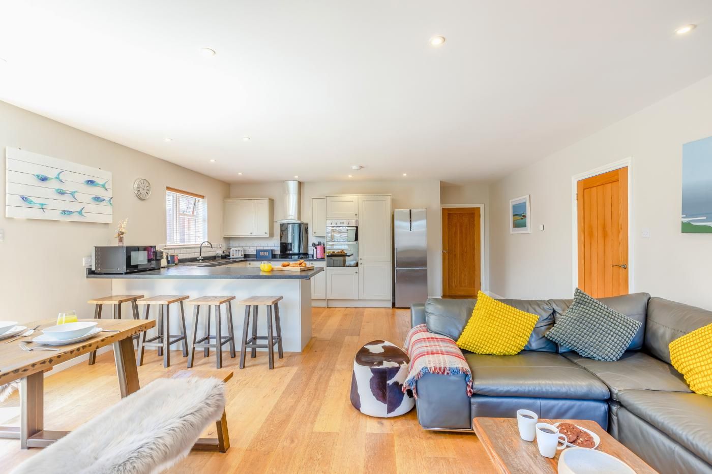 A modern living space with a kitchen, dining area, and seating area.