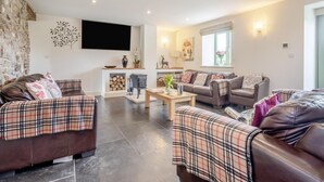A living room with two sofas, a coffee table, a fireplace, and a television. - 6 Bed in Llansantffraid (oc-r42827) (Llansantffraid)