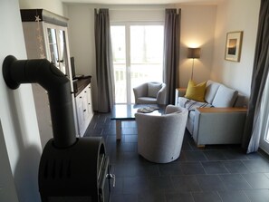 Ein modernes Wohnzimmer mit Kamin, einer Couch, einem Couchtisch und einem Essbereich.