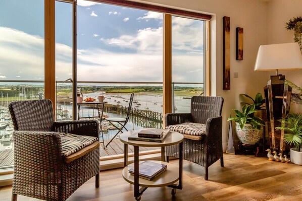 A room with large windows, wicker furniture, a small table, and a lamp. - 3 Bed in Amble (oc-s43277) (Amble)