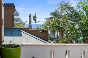 Ein Wohngebiet mit Meerblick, einer Palme und einem Gebäude mit Schrägdach.