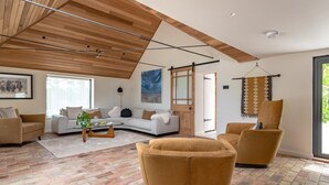 A modern living room with a curved sofa, a coffee table, and a yellow armchair. - 3 Bed in Ditchingham (oc-s42751) (Ditchingham)