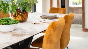 A dining area with a marble table, velvet chairs, a potted plant, and a hanging light fixture. - 3 Bed in Ditchingham (oc-s42751) (Ditchingham)