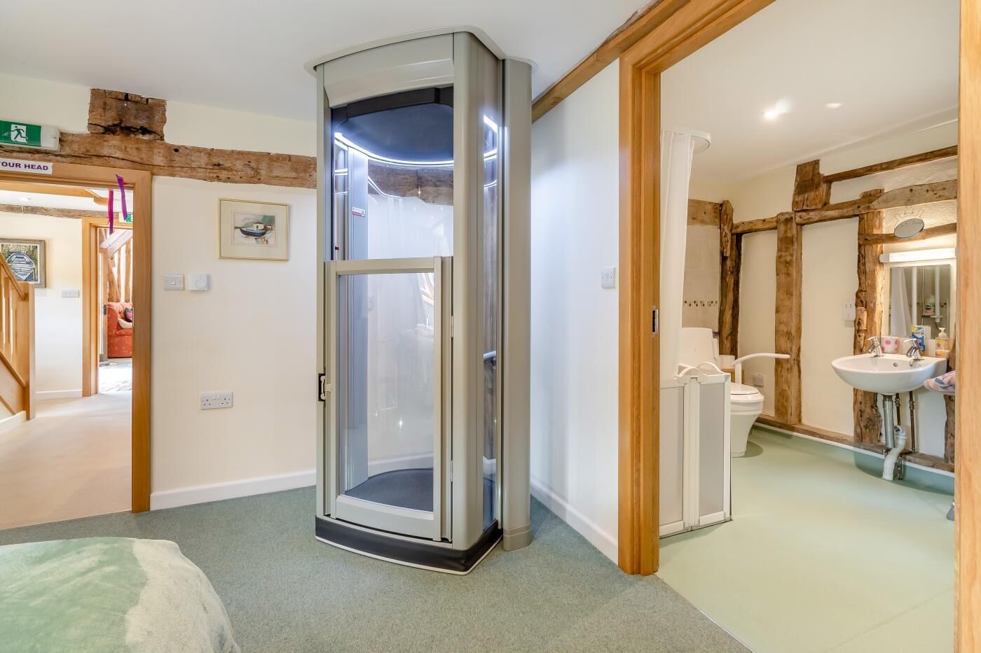 A room with a corner shower, a toilet, and a sink.
