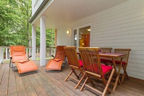 A covered outdoor area with wooden deck, lounge chairs, and a table with chairs. - Fewo 7.0.N - Ferienwohnung in Graal-Müritz (Graal-Müritz)