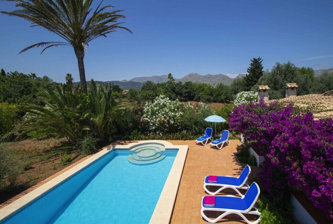 Ein Swimmingpool mit Liegestühlen und Blick auf die Berge.