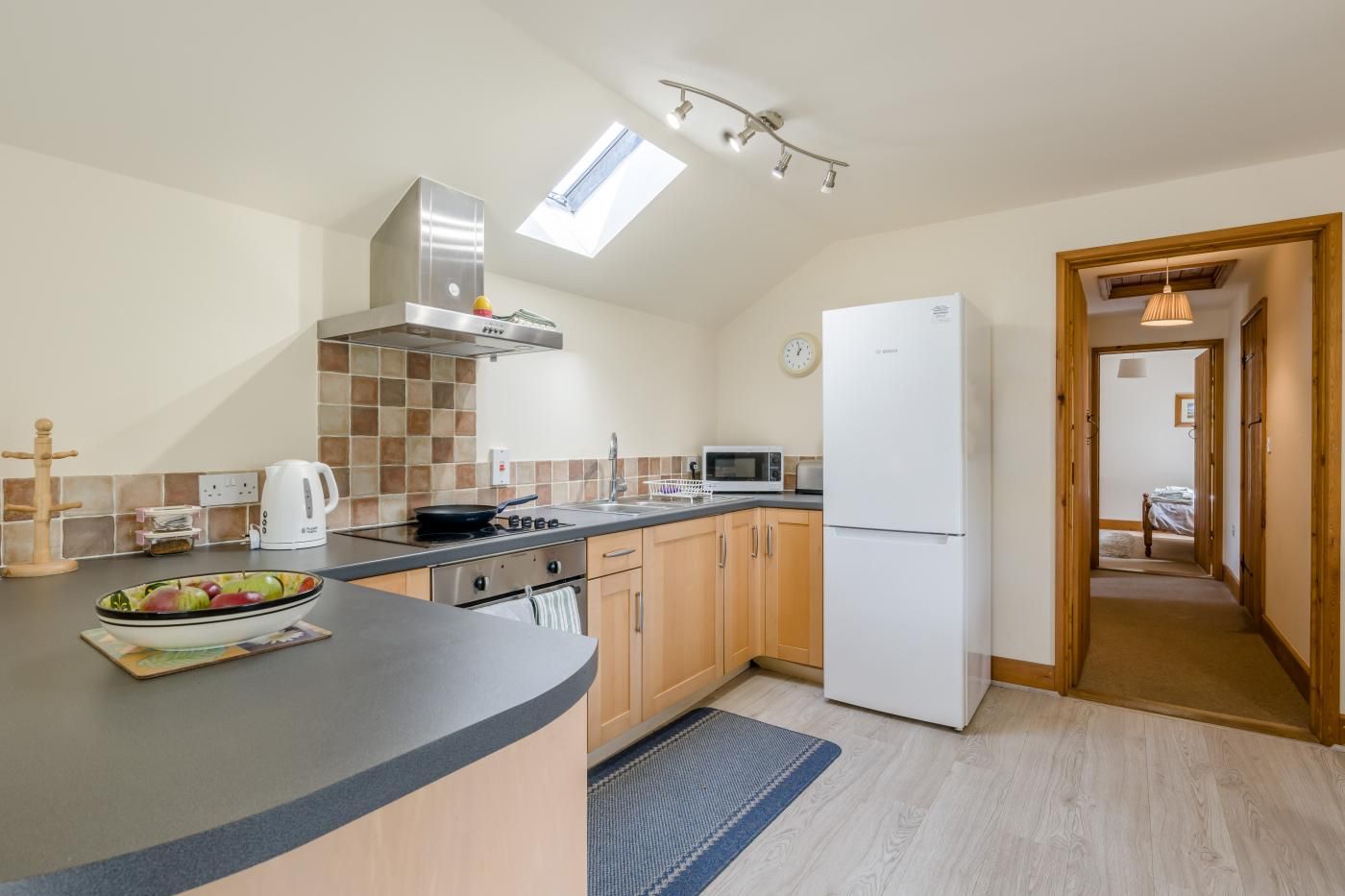 A modern kitchen with a central island, a microwave, a stove, and a refrigerator.