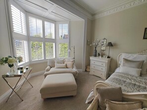 A bedroom with a large bay window, a bed, a nightstand, a dresser, and a chair. - 5 Bed in Sunderland (oc-p42853) (Sunderland)