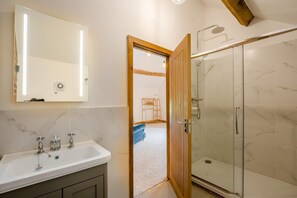 Un baño con lavabo, espejo y ducha.