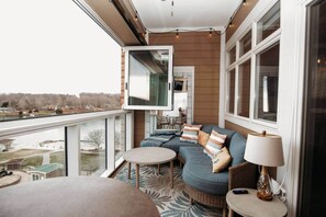 Un balcon avec un canapé, une table et une lampe.