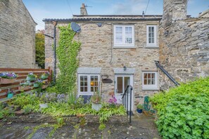 A stone building with a small garden, a satellite dish, and a door. - 2 Bed in Leyburn (oc-l42746) (Leyburn)