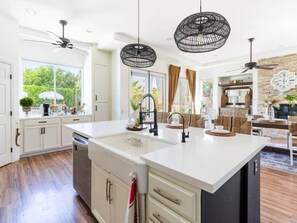 A modern kitchen with a large island, white cabinetry, and pendant lighting. - Secluded Sanctuary/ Pool/Spa/Casita/BNP/Coachella/Luxury Oasis/Gated Community (La Quinta)