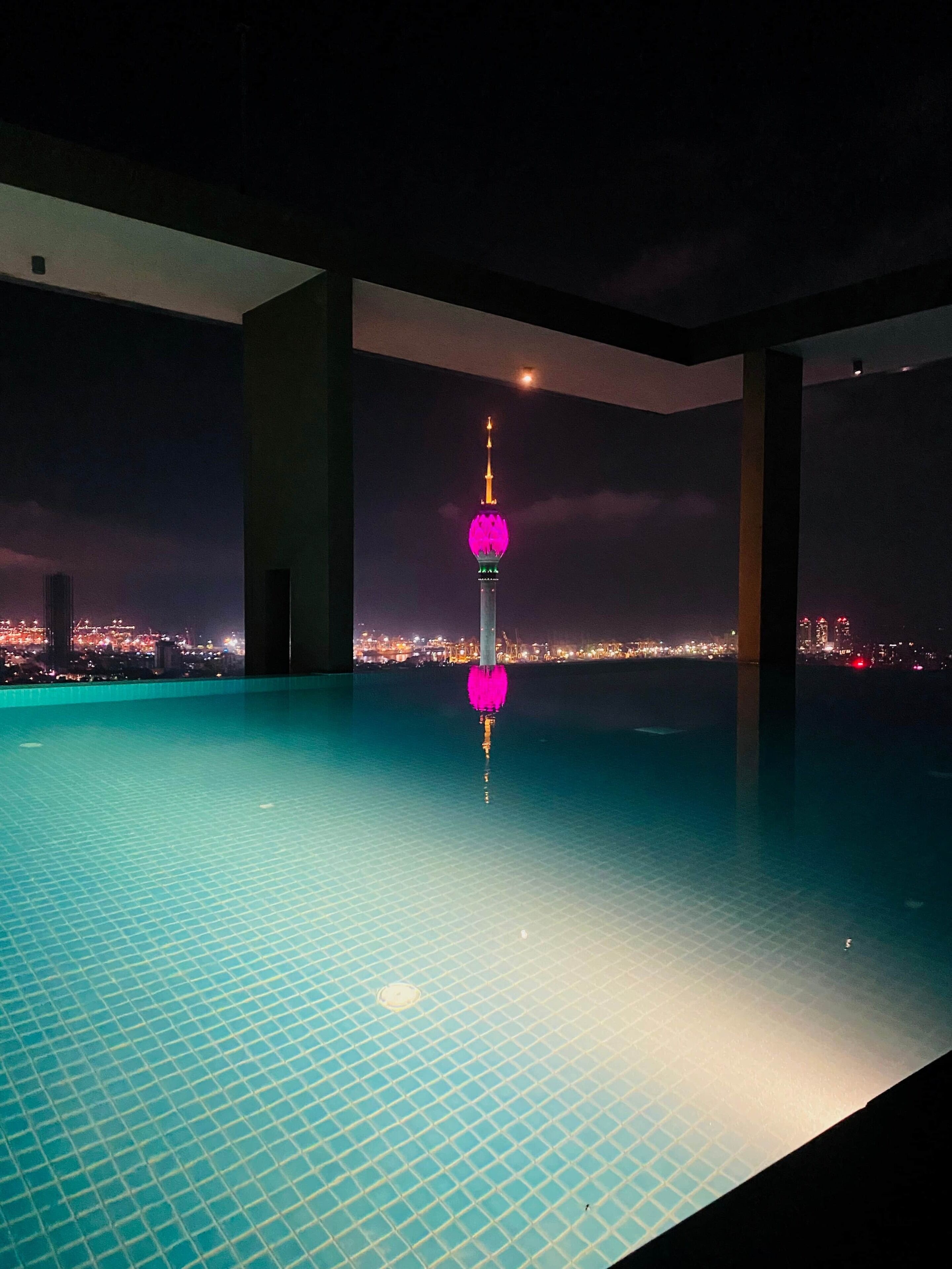 Una piscina con vistas a un paisaje urbano nocturno.