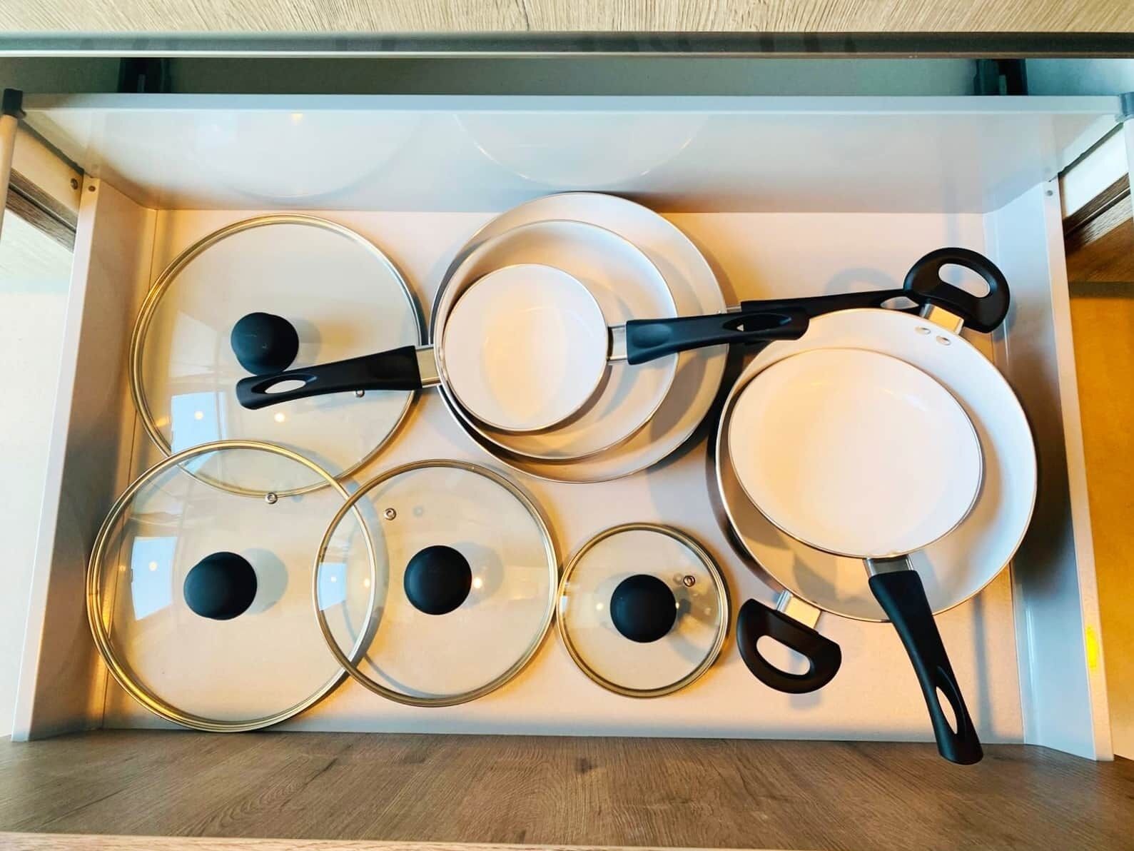 Una cocina con horno y estufa integrados, de diseño moderno con armarios blancos y electrodomésticos de acero inoxidable.