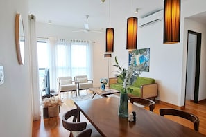 Un salon moderne avec une table à manger, des chaises, un canapé et un tableau au mur.