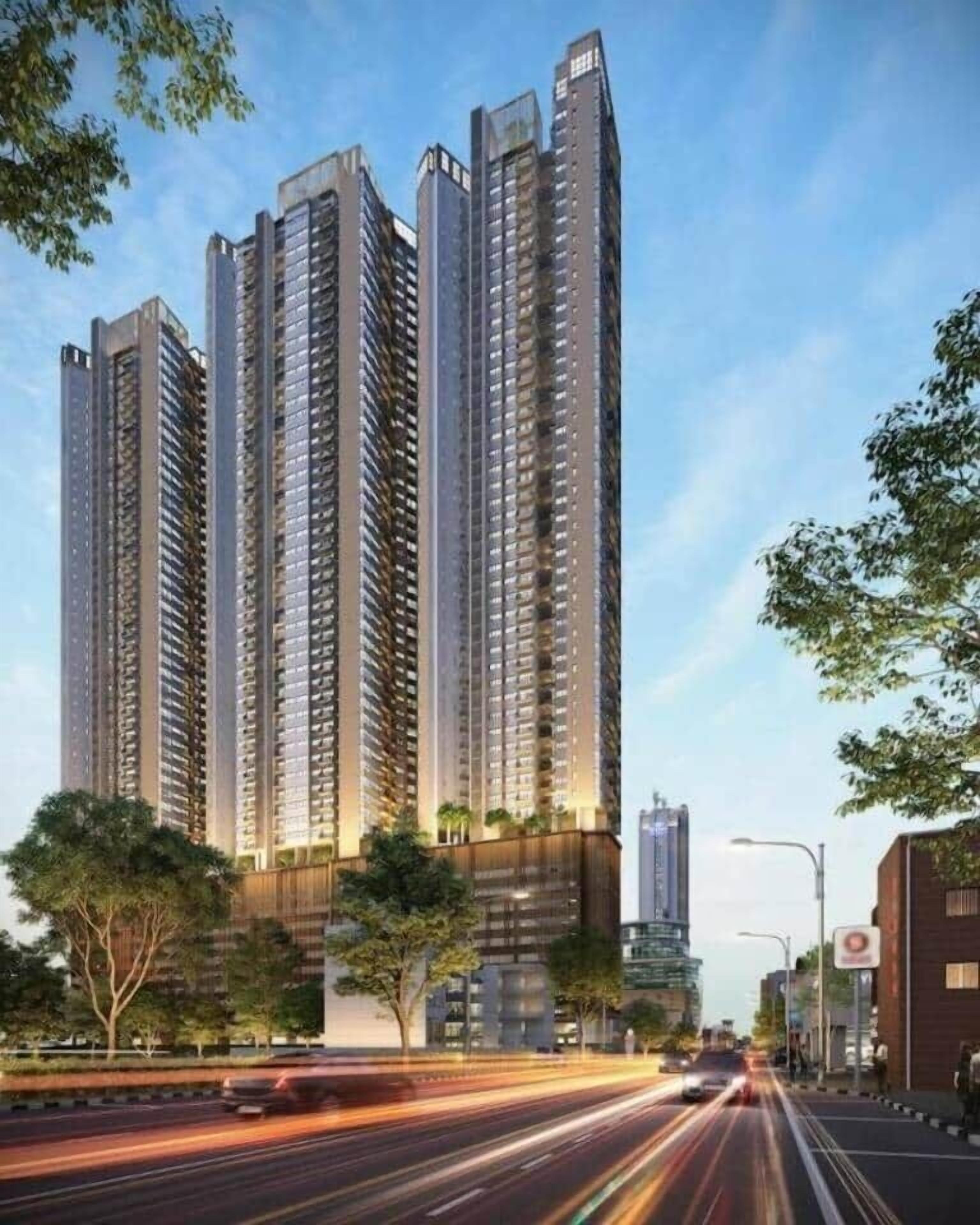 A high-rise building with multiple floors, surrounded by trees and a busy street.