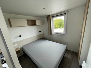A small, single-bed room with a window, a built-in shelf, and a door. - Beach 1km, 4/6 pers, St Georges - ile d'Oléron (Saint-Georges-d'Oléron)