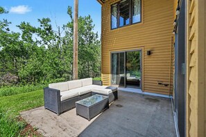 Eine moderne Außenpatio mit einer Eckcouch und einem Couchtisch mit Glasplatte.