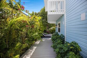 A pathway leading to a house with a balcony, surrounded by lush greenery and tropical plants. - Lovely Day Chalet - Private Pool in Old Town (Key West)
