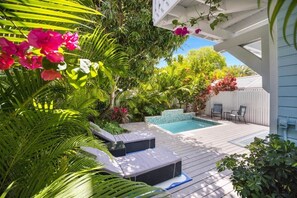 A poolside area with a wooden deck, lounge chairs, and a small pool. - Lovely Day Chalet - Private Pool in Old Town (Key West)