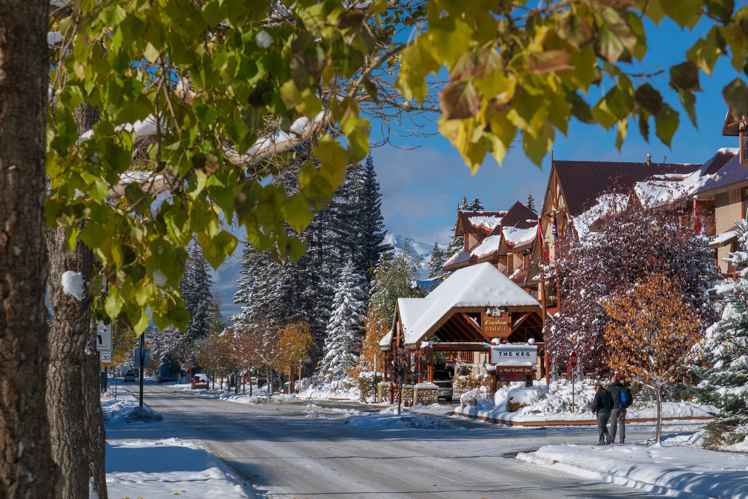 A snow-covered street with a lodge and a sign that reads "The Keg."