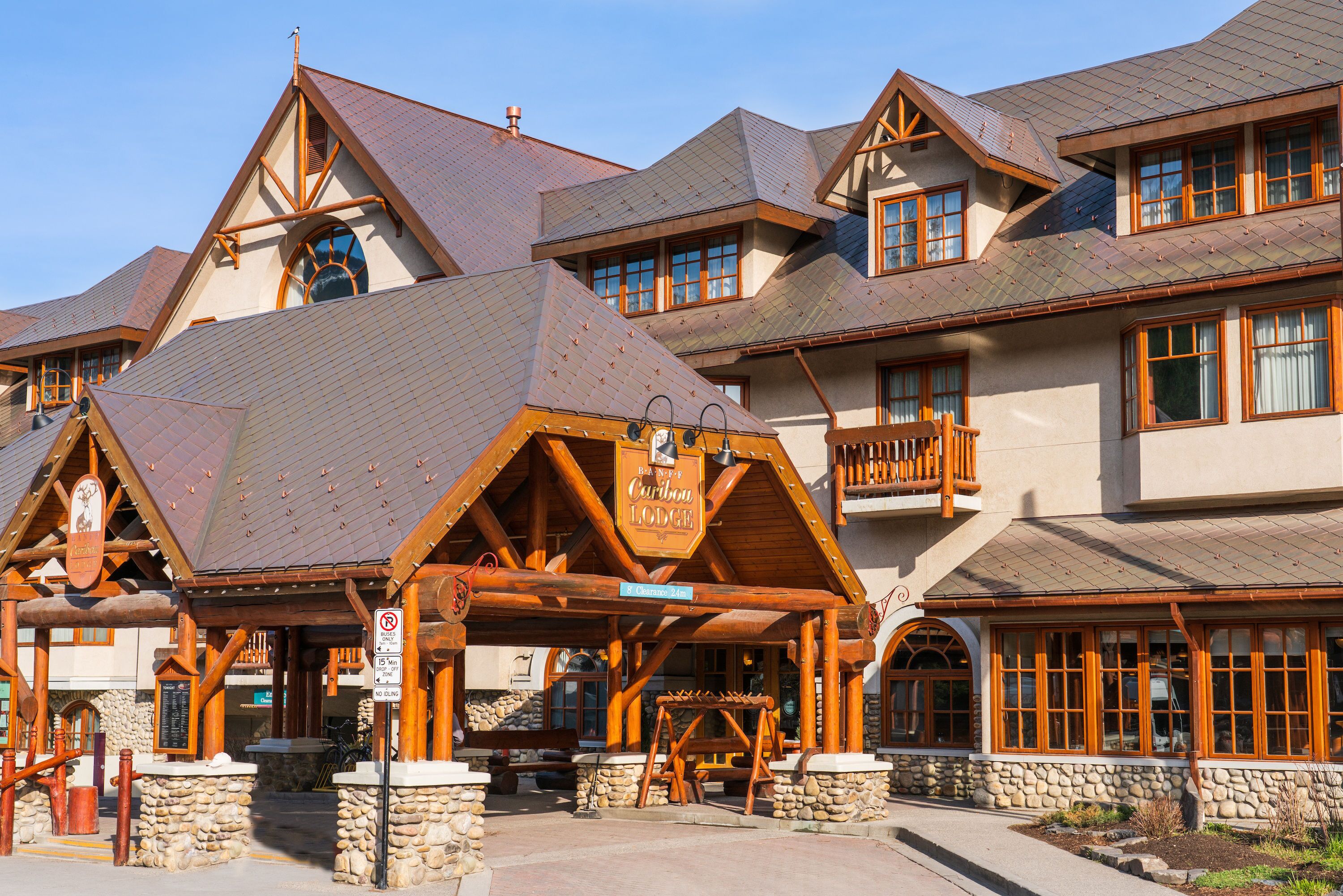 Una cabaña con fachada de piedra, balcones de madera y un letrero que indica que es el Caribou Lodge.