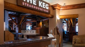 L’intérieur d’un restaurant, avec une enseigne indiquant : « THE KEG STEAKHOUSE+BAR ».