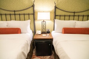 A hotel room with two beds, a nightstand with a lamp, a phone, and a minibar. - Mountain Lodge Room | Steps to Downtown Banff (Banff)